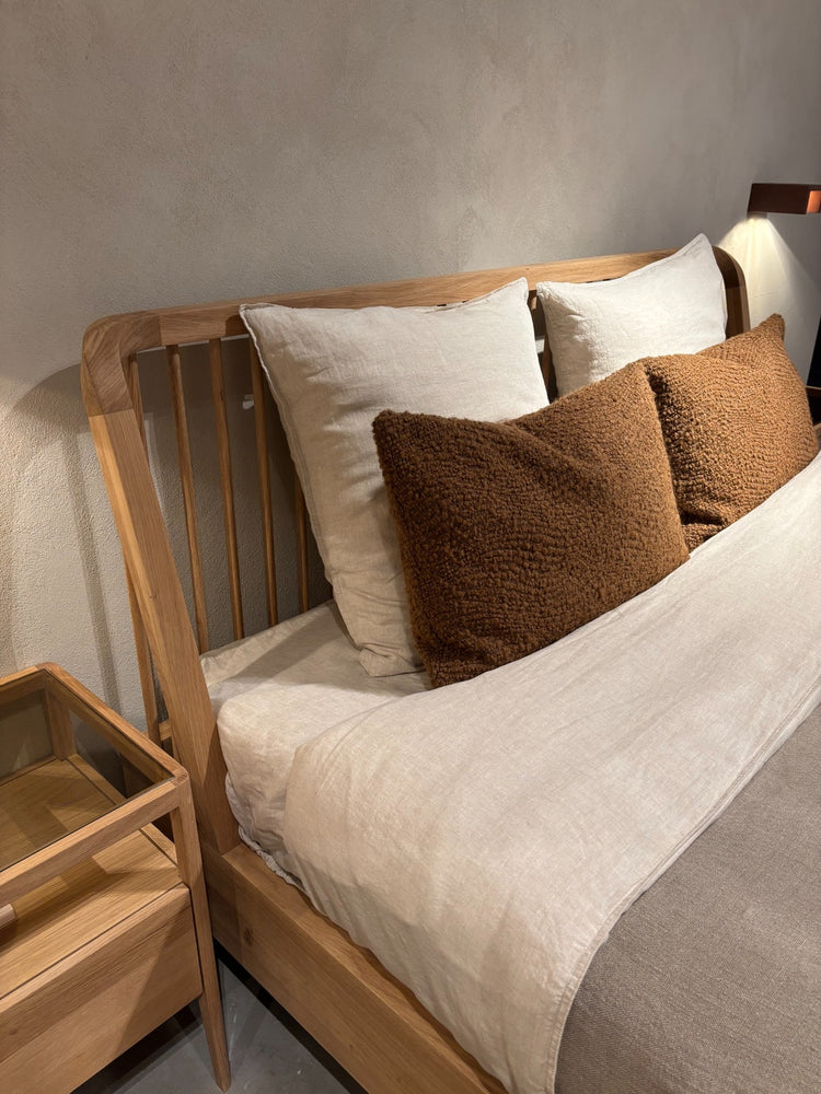Scandinavian inspired bedroom design featuring natural wood bed and soft linen cushions.