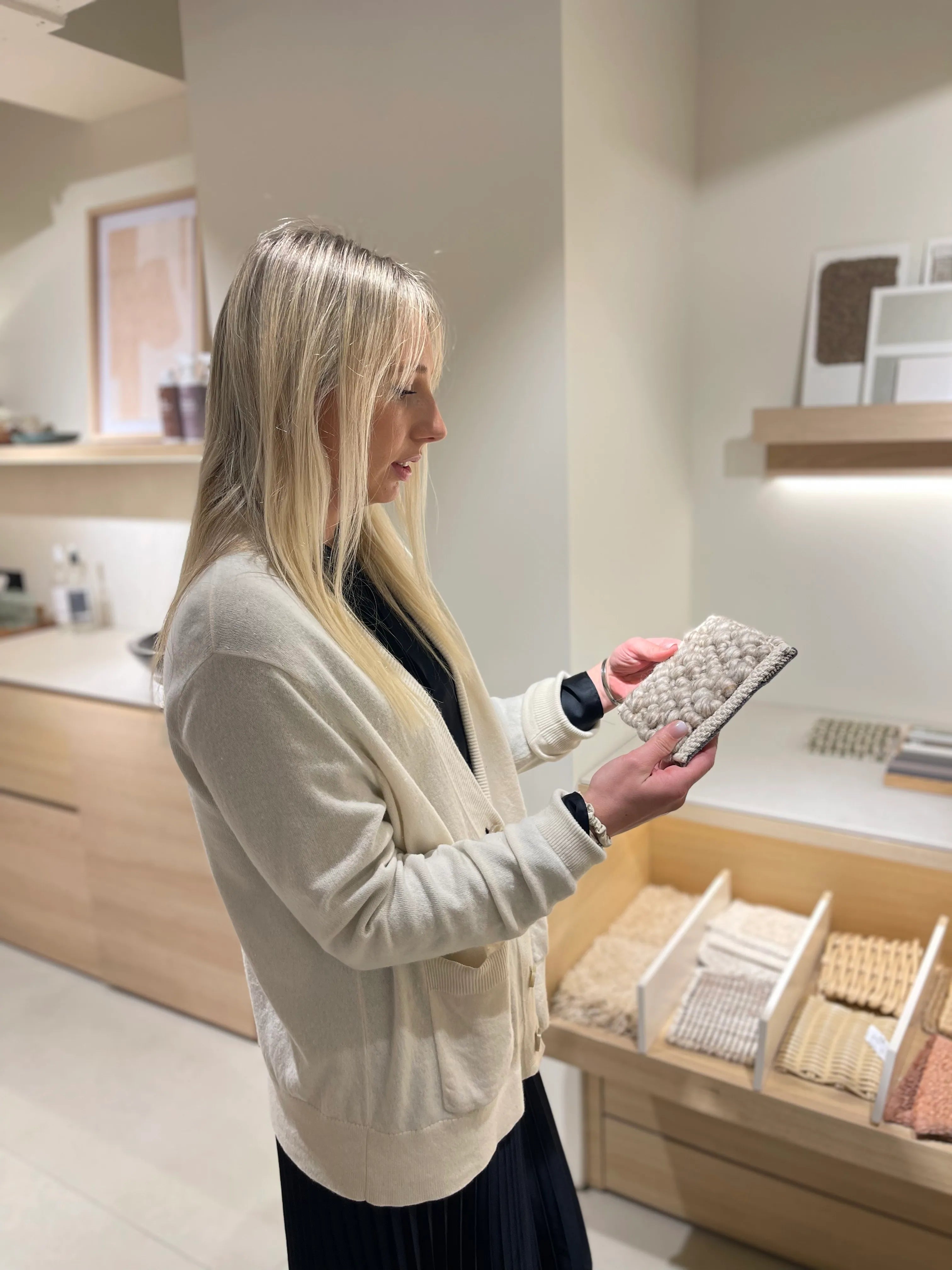 Interior Designer Looking at rug samples in a scandinavian inspired interior.